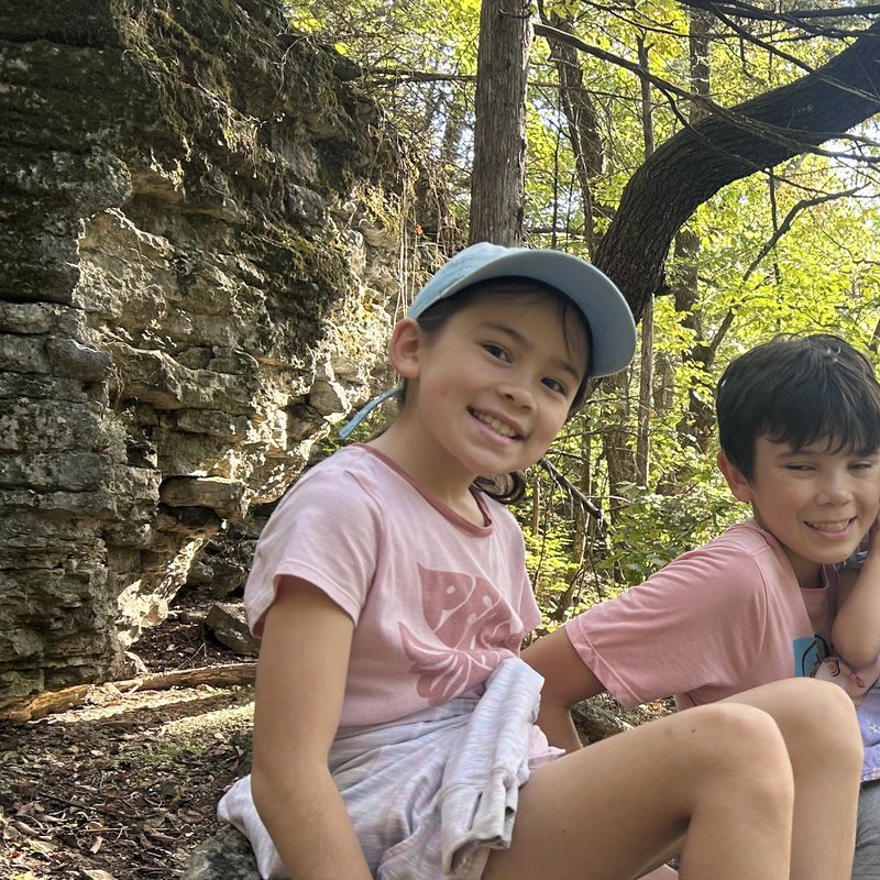 Serene smiling on a rock in the woods